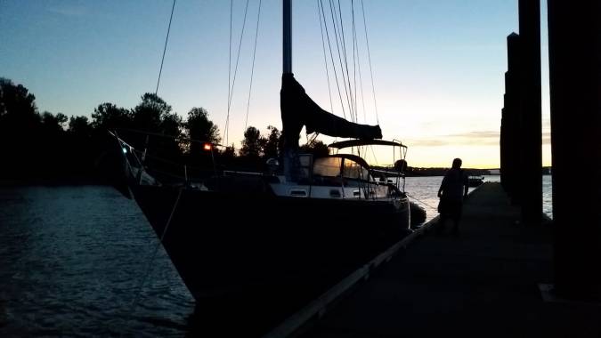 Sailboat tied to a dock at dusk