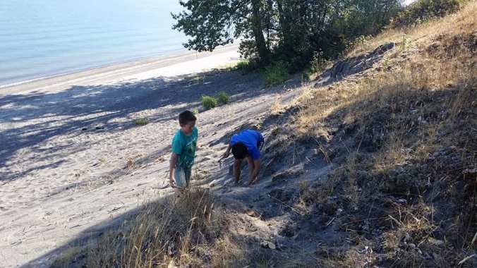 Two boys playing in the sand on a large sand dune on the Columbia River