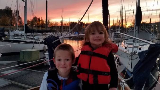 Two kids living aboard a sailboat with their family.