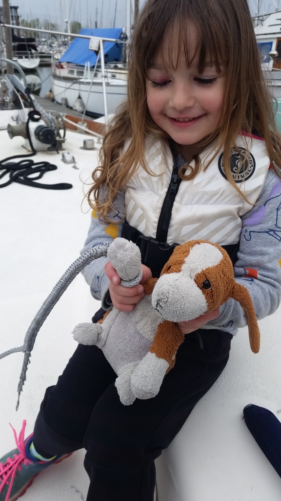 A girl and her stuffed dog help with splicing for the family's Dyneema lifeline project